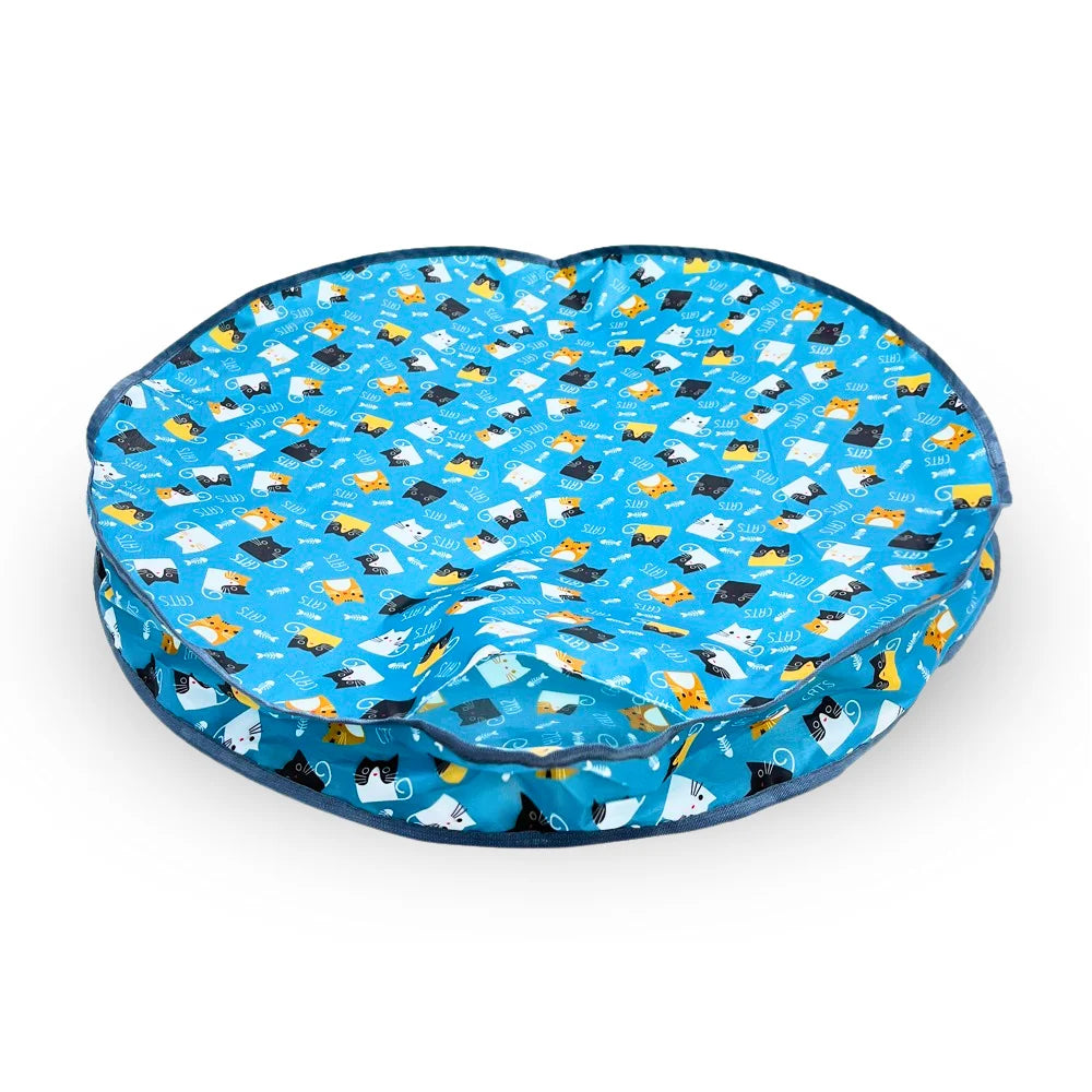 The HUNTING COVER cat bed in blue features a playful cartoon cat pattern with colorful cats and paw prints, perfect for felines who enjoy a lively hunting vibe during rest.