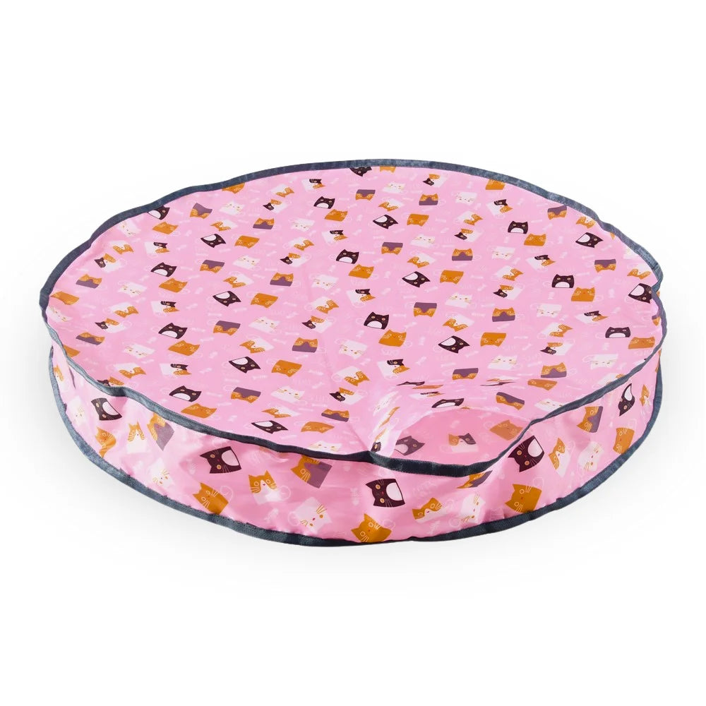 The HUNTING COVER is a round pink pet bed decorated with small cartoon cats wearing colorful masks, creating a charming hideaway for your pet's playful adventures.