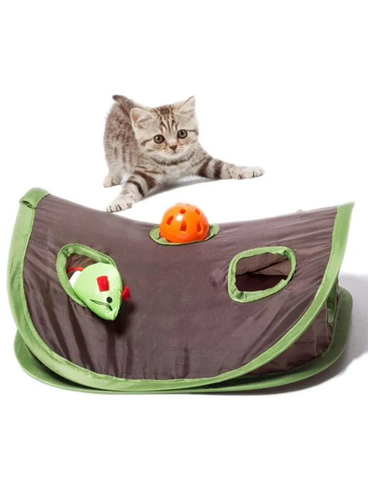 A playful kitten hides behind a green and brown fabric play tent featuring the Cute Pet Cat Interactive Hide Seek Game, with a mouse hunt toy and an orange ball for endless fun with foldable toys.