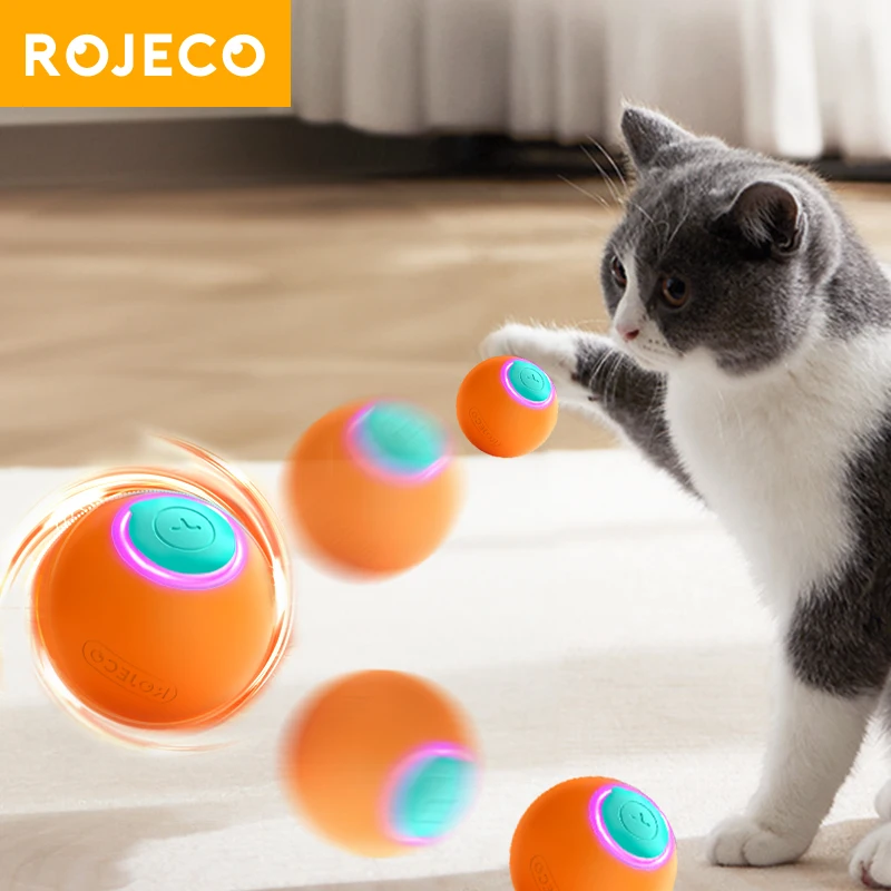 A cat enthusiastically plays indoors with the ROJECO Smart Interactive Cat Bouncing Ball, an electric toy that automatically rolls, emitting colorful lights to captivate and entertain.